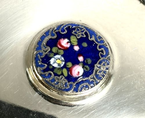 A round cut glass vanity jar topped with a hallmarked sterling silver lid featuring a central blue floral enamel motif. View VI