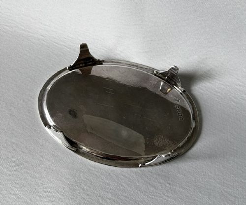An oval Georgian silver teapot stand featuring an engraved Greek key border, a central cartouche, and four small supportive feet. View IV