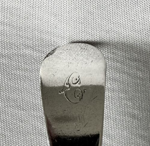 fig 1. An 18th-century sterling silver serving spoon featuring an oval bowl and a tapered stem stamped with provincial hallmarks near the terminal.