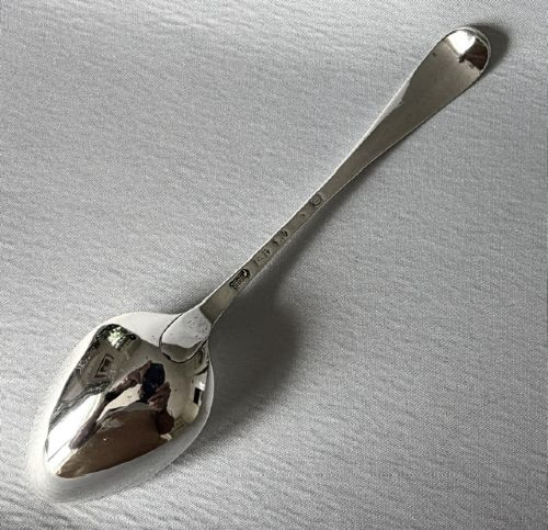 An 18th-century sterling silver serving spoon featuring an oval bowl and a tapered stem stamped with provincial hallmarks near the terminal. View III