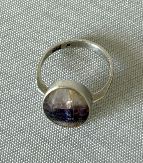 A mid-century sterling silver ring featuring a large oval Blue John cabochon stone with distinct purple and cream banding, set in a plain bezel mount. View III