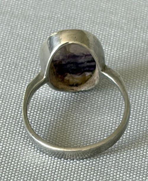 A mid-century sterling silver ring featuring a large oval Blue John cabochon stone with distinct purple and cream banding, set in a plain bezel mount. View IV
