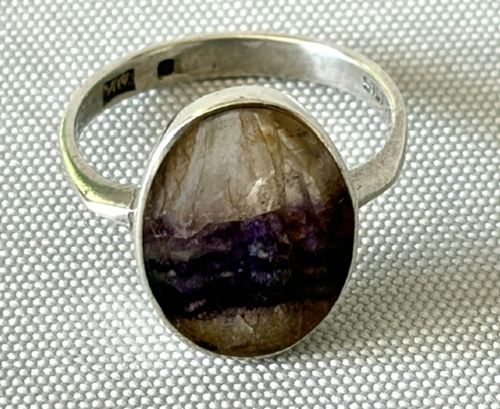 A mid-century sterling silver ring featuring a large oval Blue John cabochon stone with distinct purple and cream banding, set in a plain bezel mount. View V
