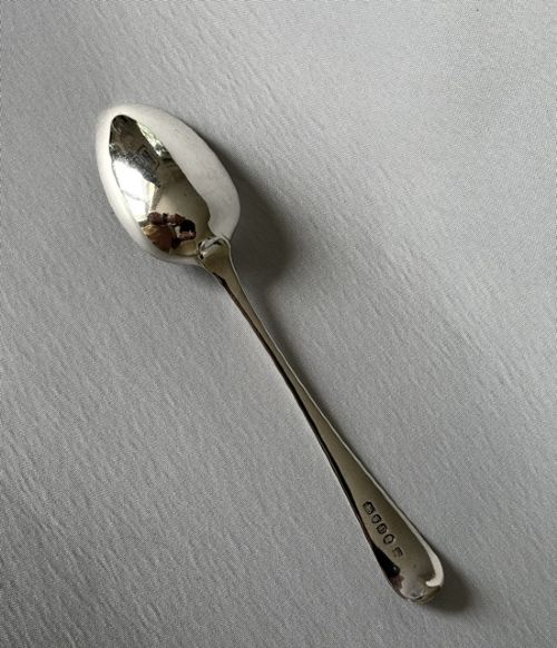 fig 1. A Georgian sterling silver tablespoon featuring an elongated oval bowl and a smooth tapered stem against a light grey background.