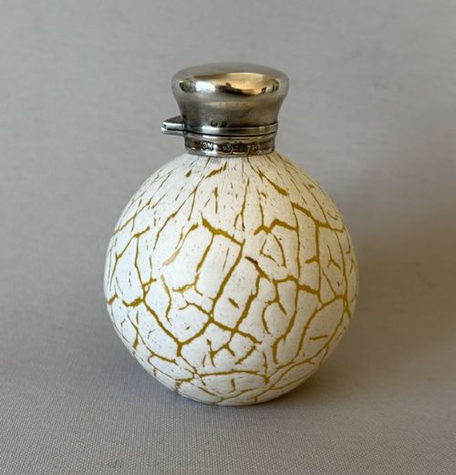 A spherical Victorian crackle glass scent bottle featuring a silver hallmarked hinged cap. View III