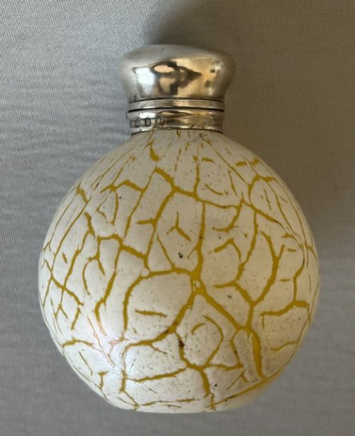 A spherical Victorian crackle glass scent bottle featuring a silver hallmarked hinged cap. View VIII