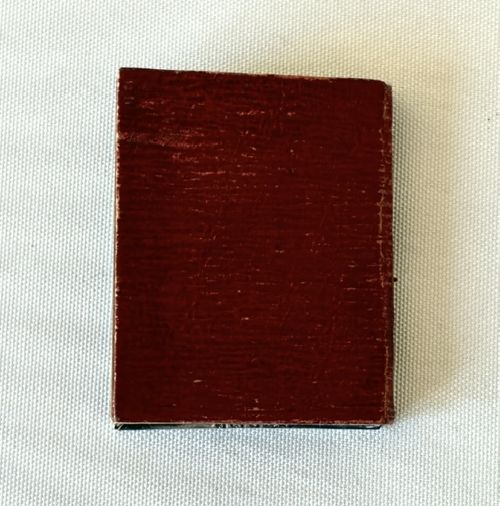 fig 1. A miniature Edwardian book-shaped pocket calendar featuring an embossed silver front cover with detailed scrollwork and a central latticework pattern.