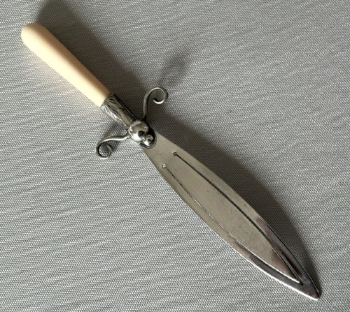 An Edwardian silver bookmark in the shape of a dagger featuring a hallmarked blade, scroll crossguard, and cream bone handle. View IV