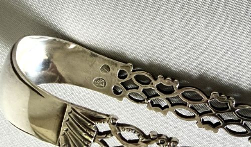 A pair of 18th-century cast silver sugar tongs featuring openwork lattice arms and shell-shaped grips. View V