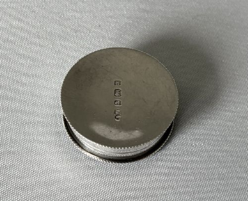 A small circular silver box featuring hand-engraved foliage and scroll patterns surrounding an unengraved circular centre. View IV