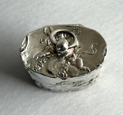 An early nineteenth-century Dutch silver miniature tea caddy featuring relief repousse scenes of classical figures on an oval body with a fitted lid. View VIII