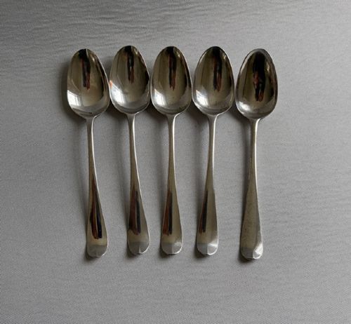 fig 1. A set of five sterling silver teaspoons arranged in a fan shape showing plain stems and oval bowls.