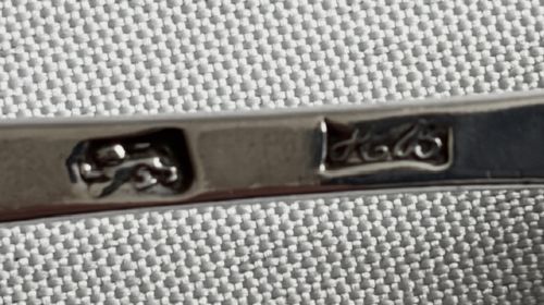 A set of five sterling silver teaspoons arranged in a fan shape showing plain stems and oval bowls. View IV