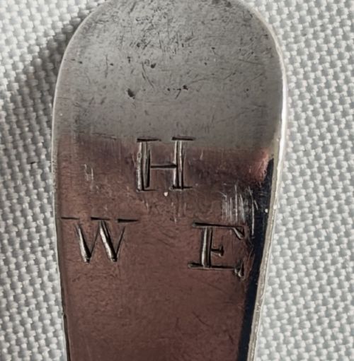 A set of five sterling silver teaspoons arranged in a fan shape showing plain stems and oval bowls. View V