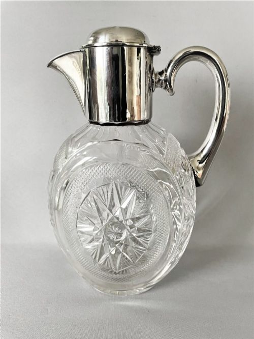 A Victorian silver-mounted cut glass claret jug featuring a globular body with starburst facets, a hinged lid, and a smooth silver handle. View III