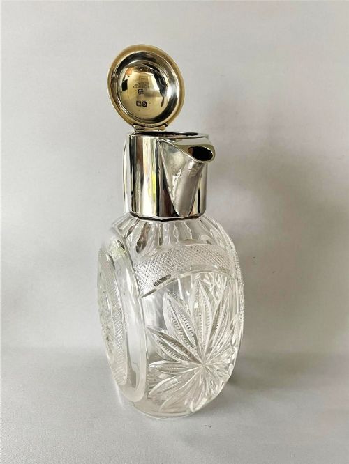 A Victorian silver-mounted cut glass claret jug featuring a globular body with starburst facets, a hinged lid, and a smooth silver handle. View V