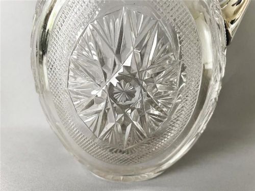 A Victorian silver-mounted cut glass claret jug featuring a globular body with starburst facets, a hinged lid, and a smooth silver handle. View VI