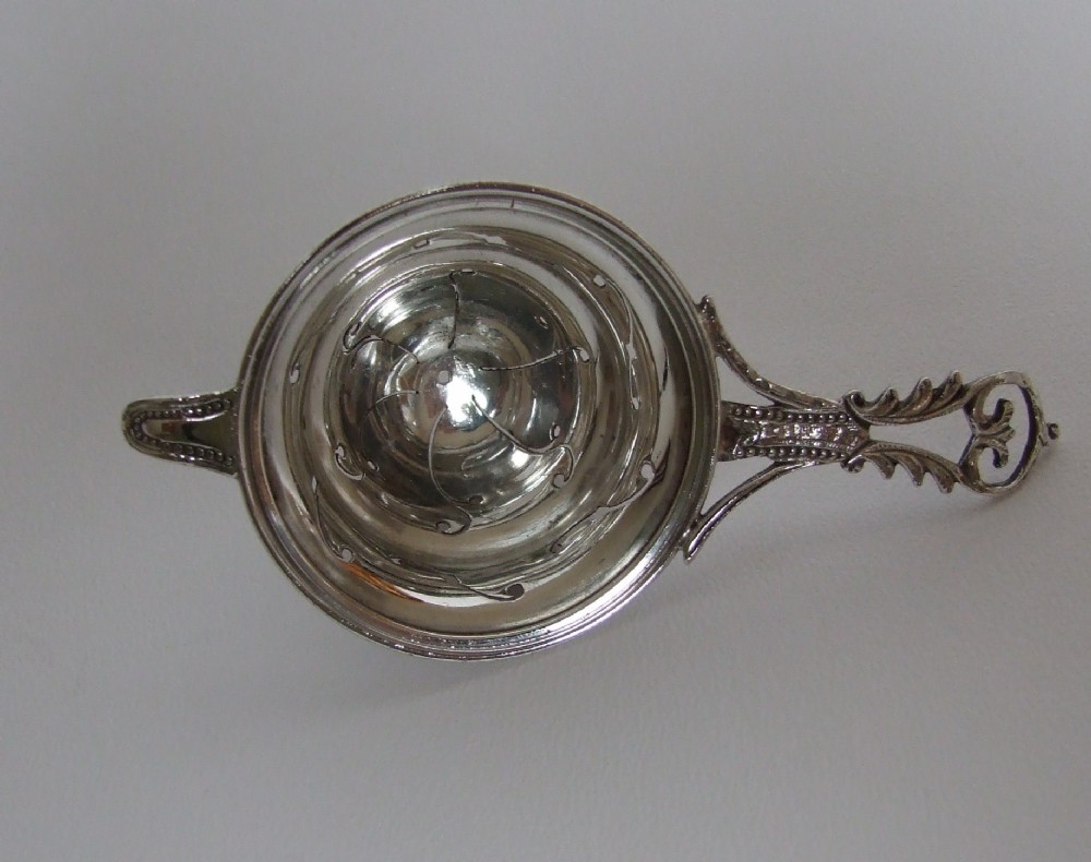 A gorgeous small silver tea strainer.