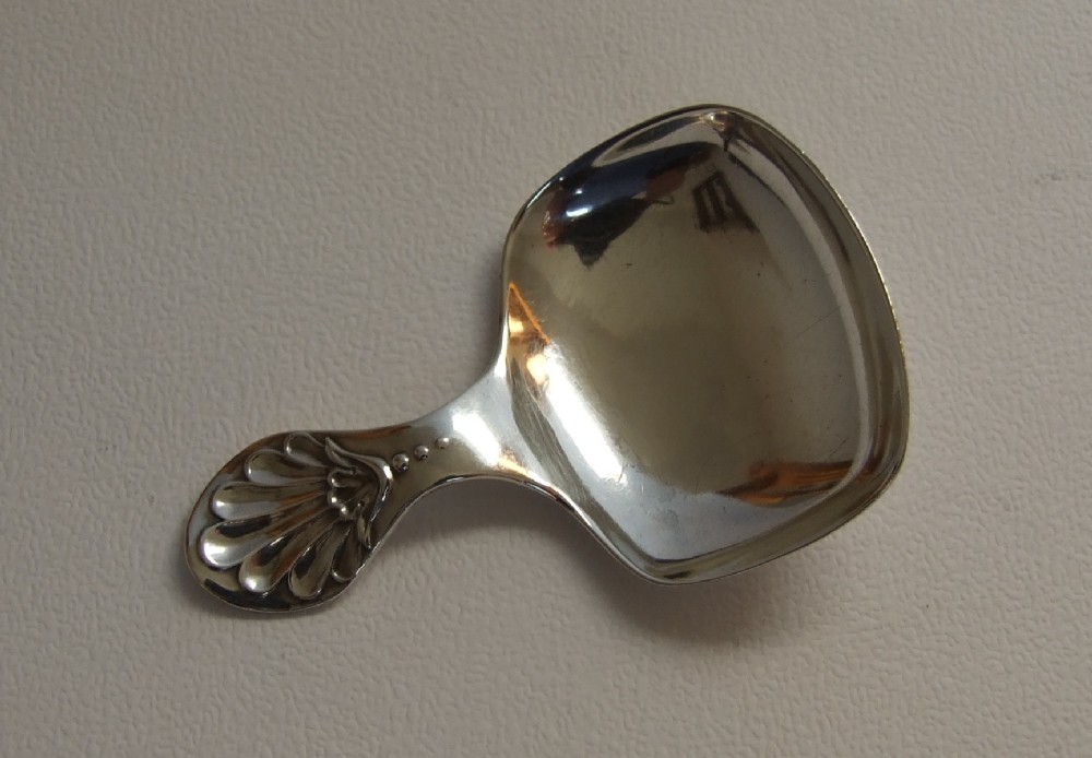 A hallmarked silver caddy spoon with shell handle.