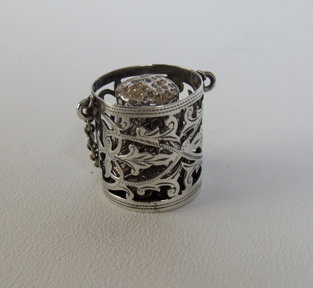 A lovely Edwardian pierced silver thimble holder with thimble.