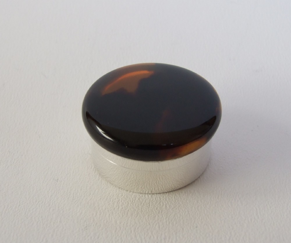 A charming silver pillbox with tortoiseshell lid.