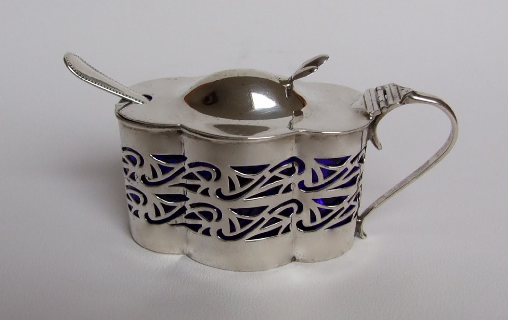 An unusual Edwardian silver shaped mustard pot & spoon.