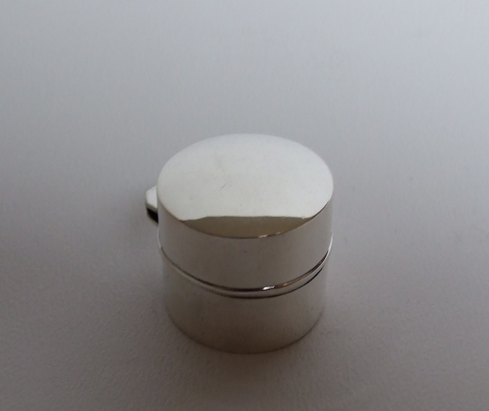 An Edwardian silver pillbox with hinged lid.