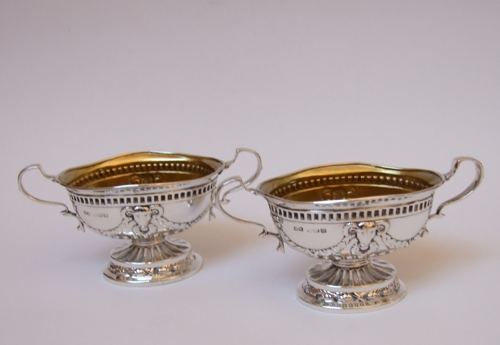 A wonderful pair of silver condiment tubs, with Rams head decoration.