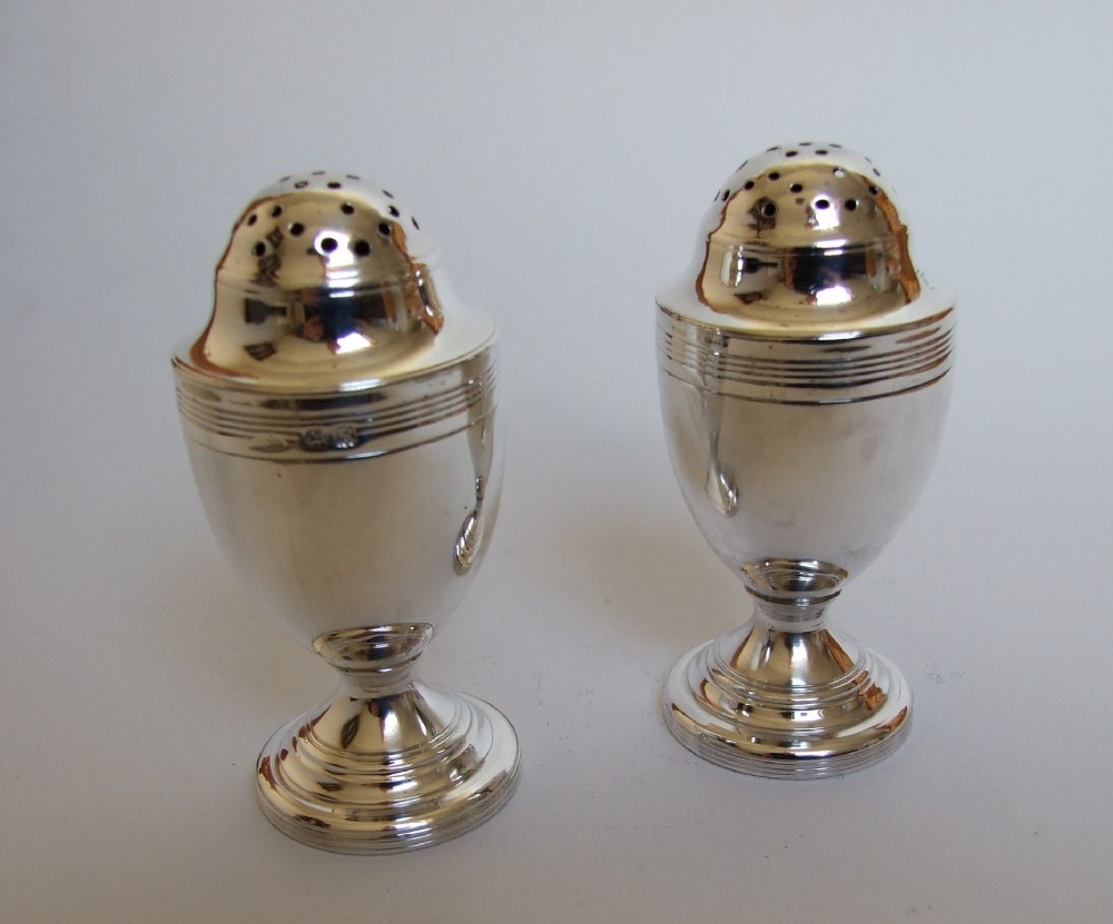 A rare pair of Georgian silver pepper pots, by a female silversmith.