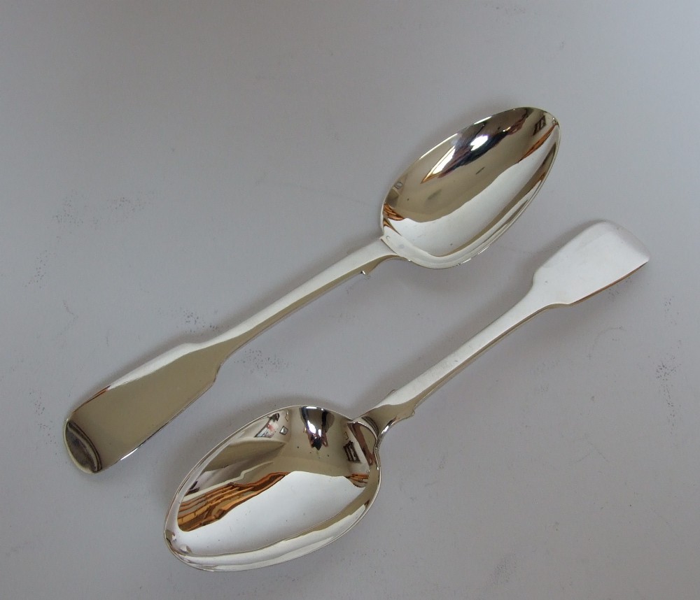 A fine pair of silver fiddle pattern dessert spoons.