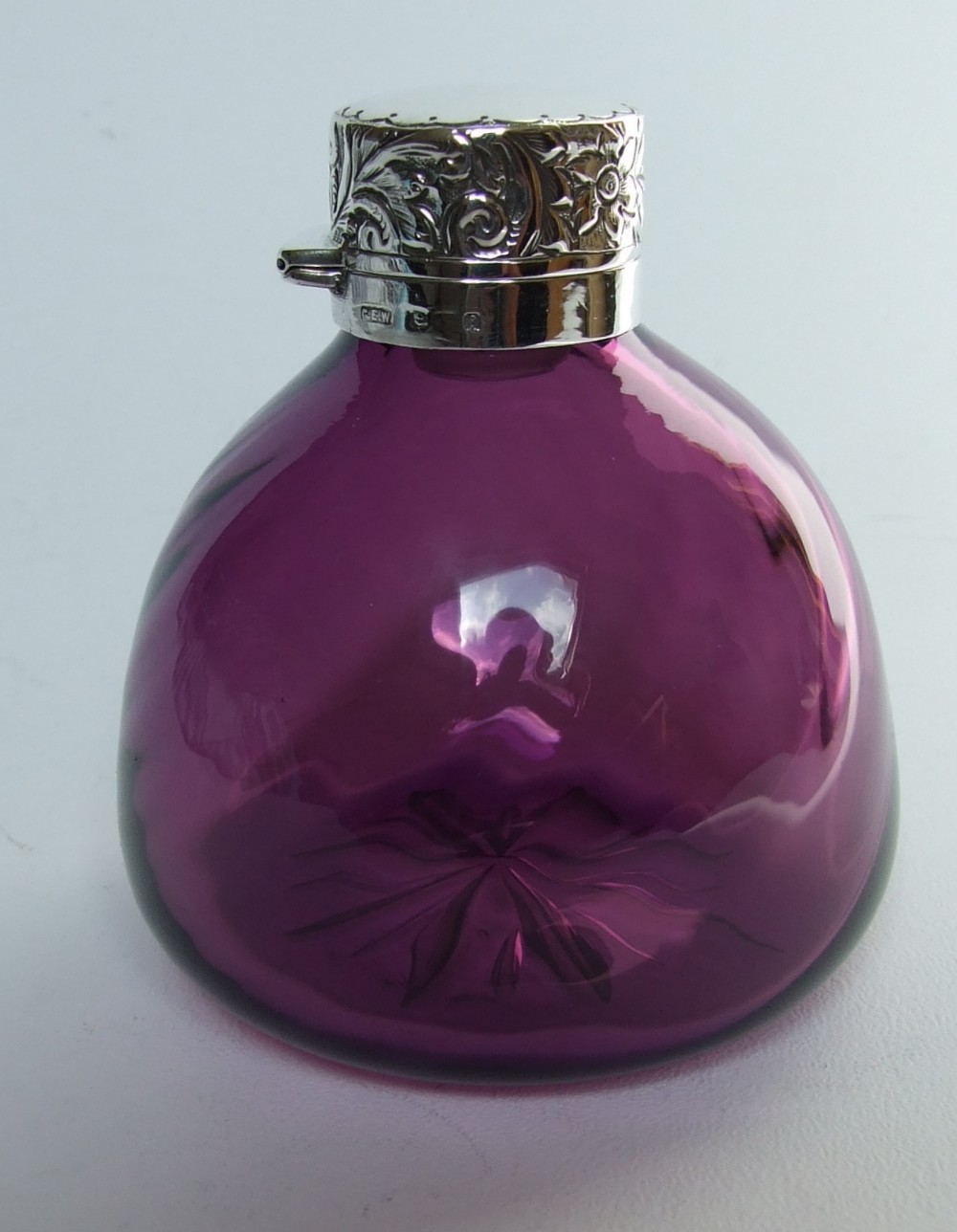 A gorgeous silver mounted amethyst glass cologne bottle.