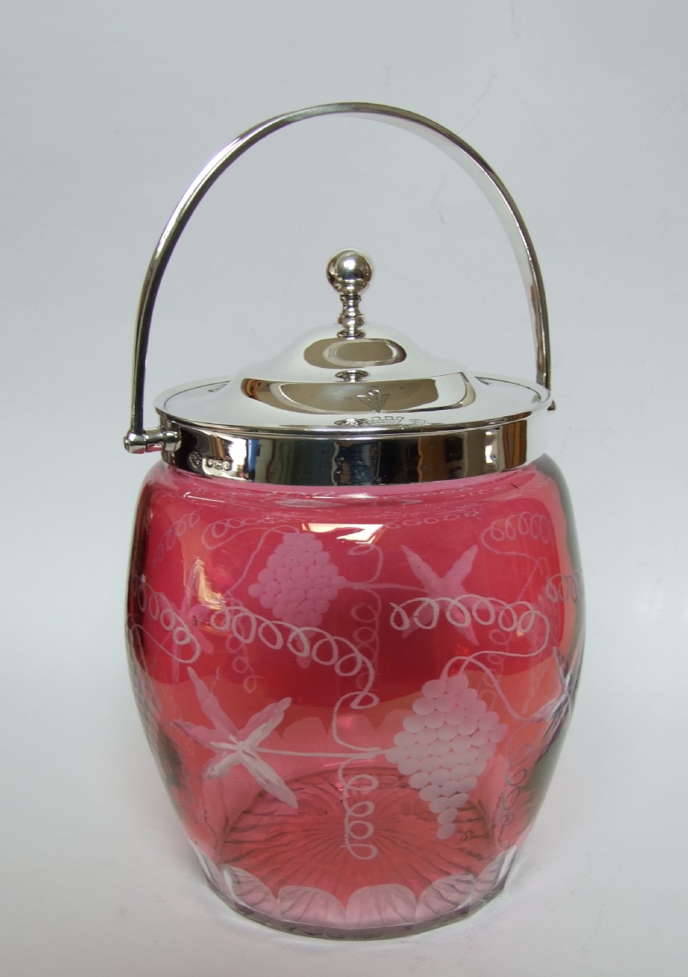 A stunning silver mounted cranberry biscuit barrel.