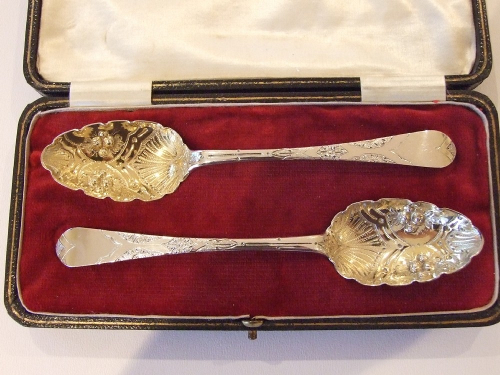 A wonderful pair of boxed Newcastle silver gilt fruit spoons.