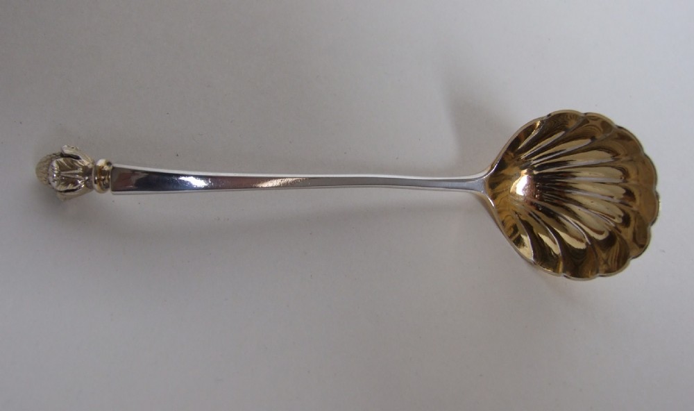 A fabulous Victorian cast silver gilt cream ladle