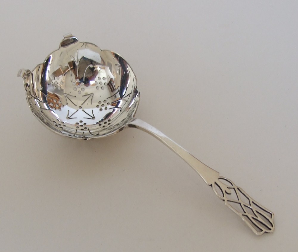A gorgeous George V silver tea strainer.