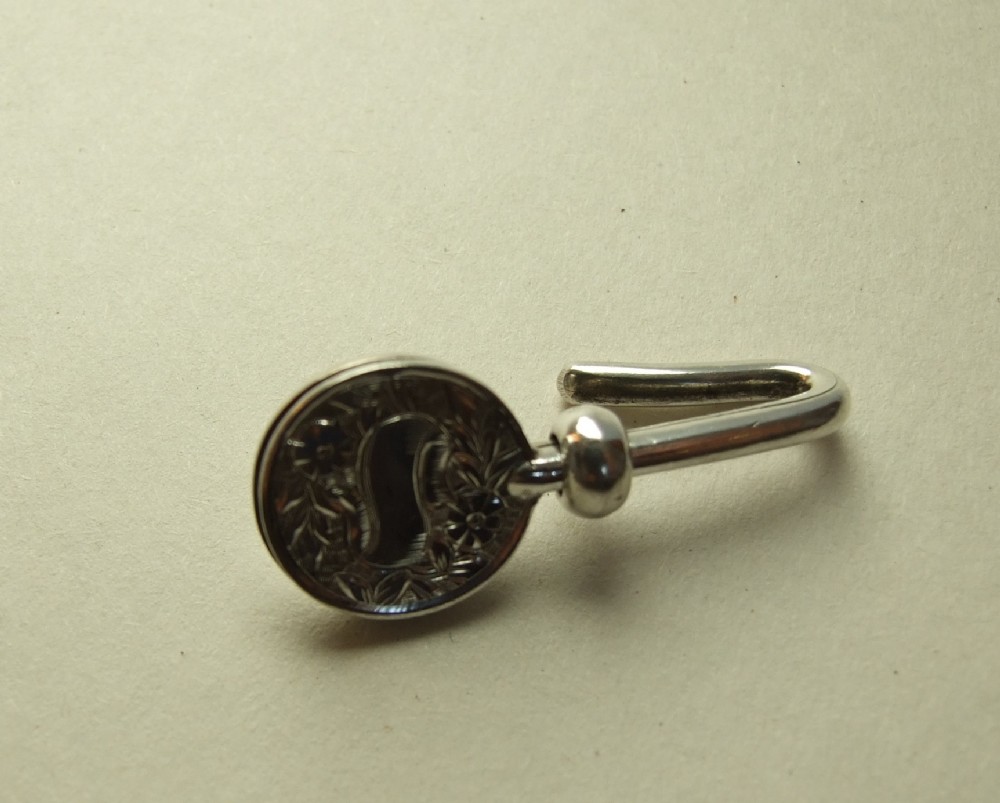 A charming Victorian silver napkin clip.