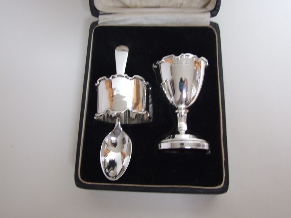 A lovely George V boxed silver egg cup, spoon and napkin ring.