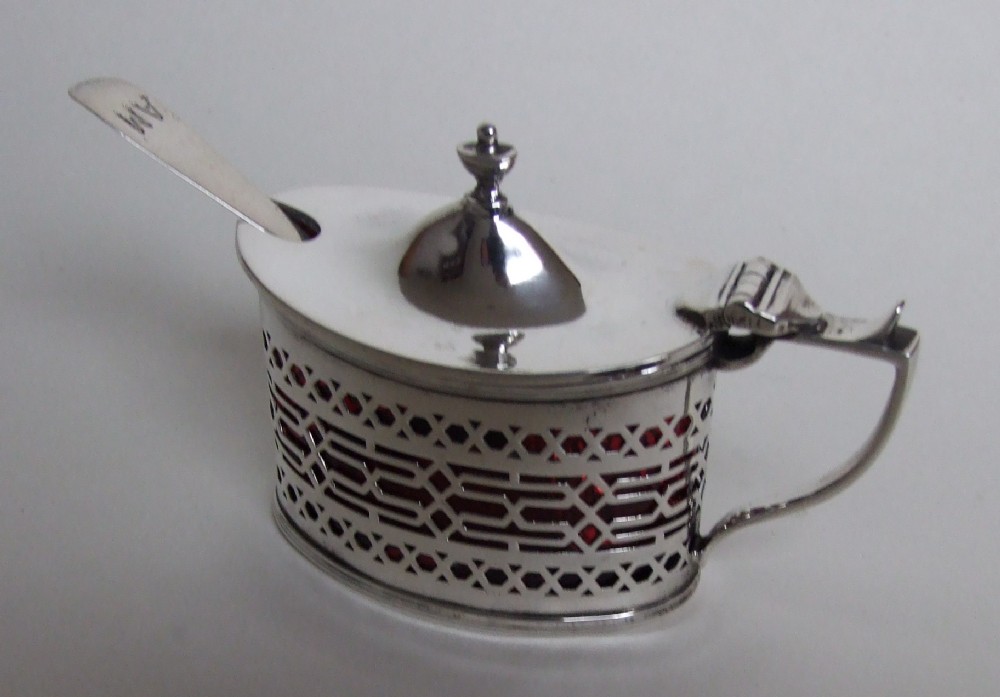 A handsome silver mustard pot with unusual cranberry liner.