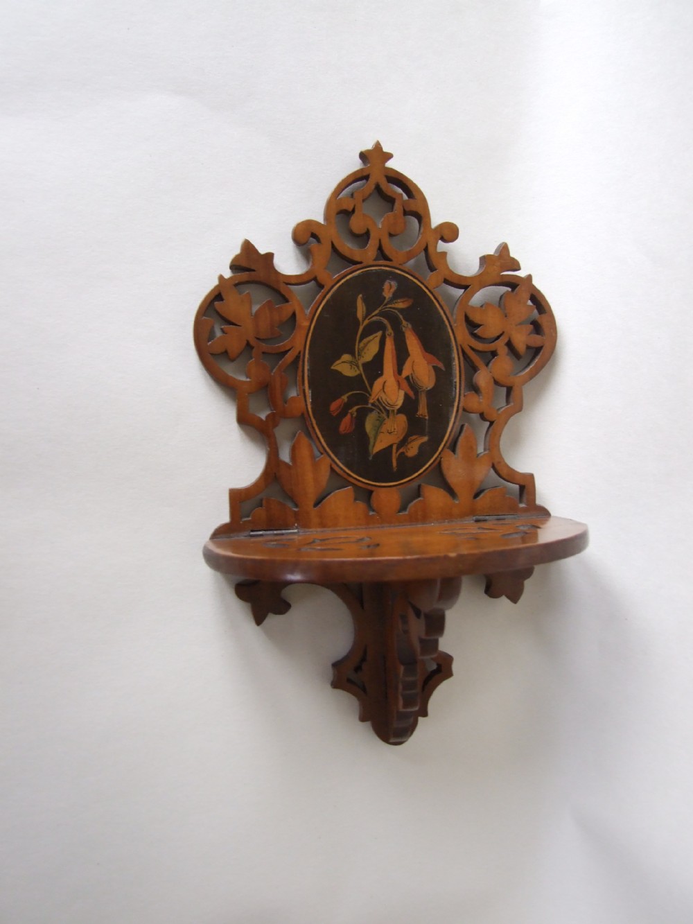 A delightful Art Nouveau small carved wall bracket with inlaid flowers.