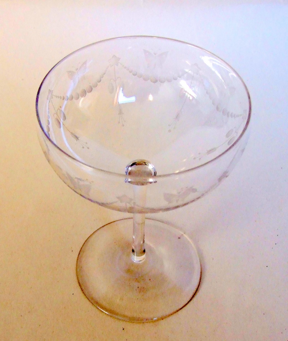 A butterfly engraved Victorian champagne glass.