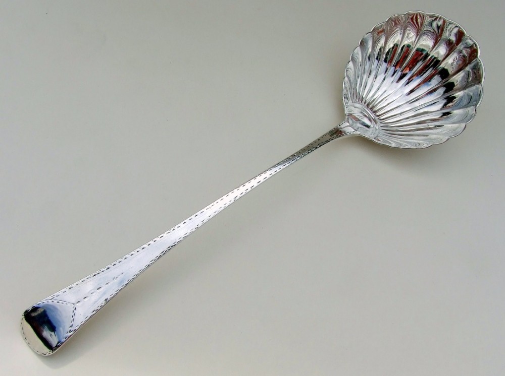 A superb George III shell bowl silver soup ladle.