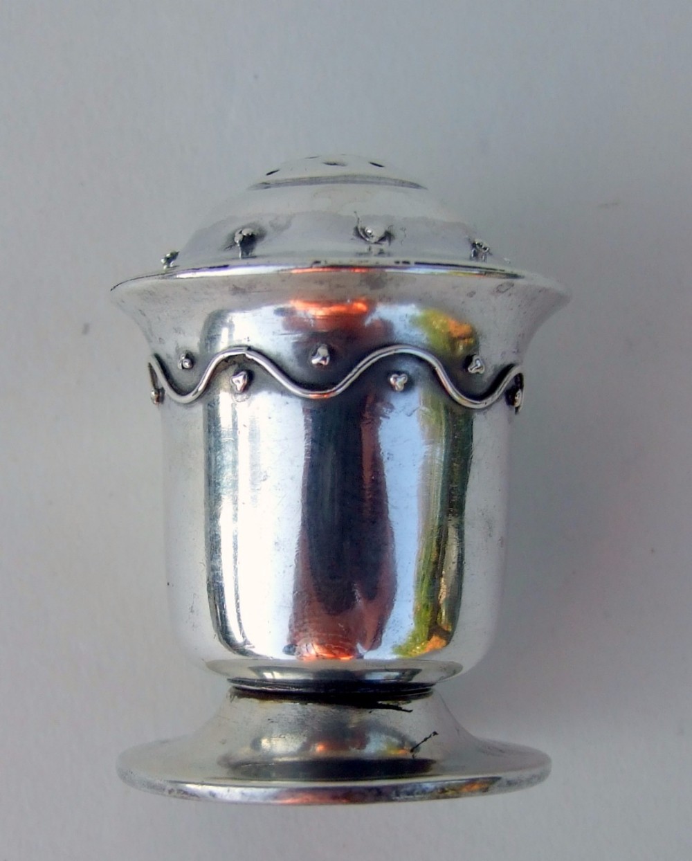 A rare Liberty & Co. Arts & Crafts silver pepper pot.