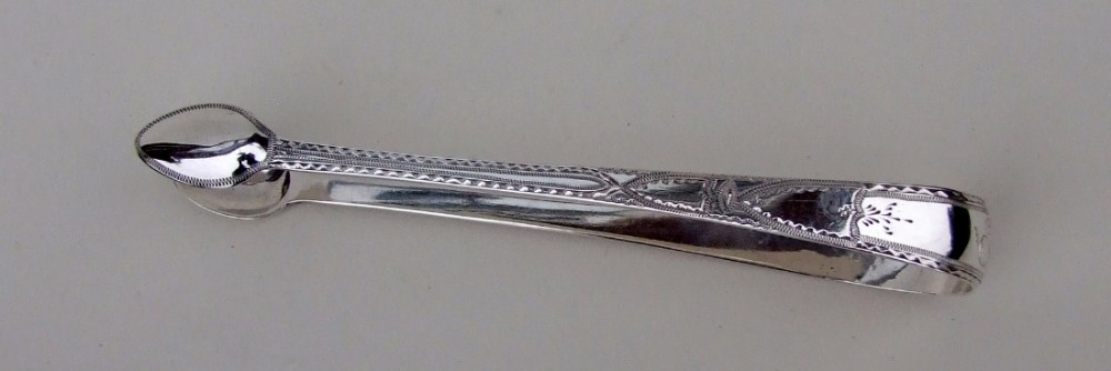 A gorgeous pair of 18th Century Bright cut silver tongs.