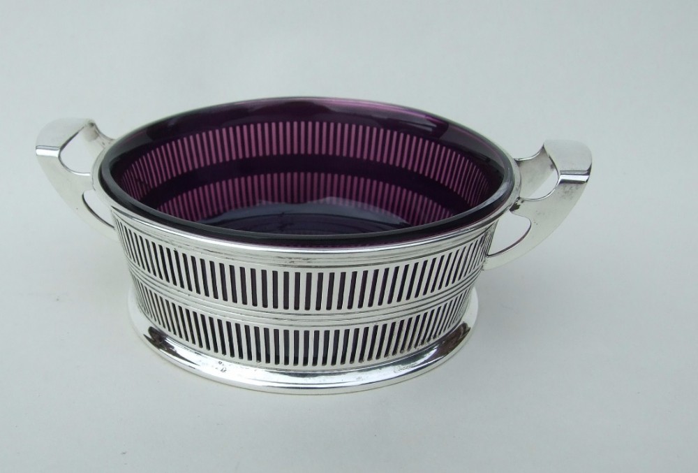 A gorgeous pierced silver twin handled dish with amethyst glass liner.