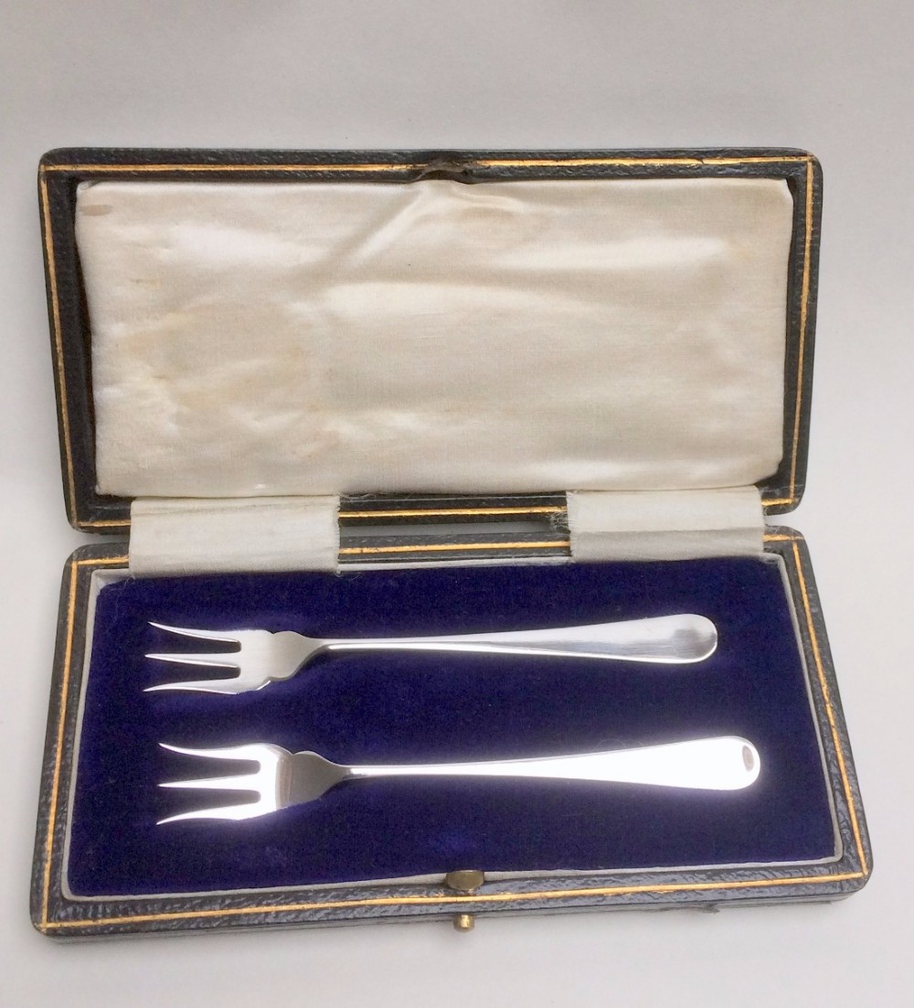 A charming boxed pair of silver pickle forks.