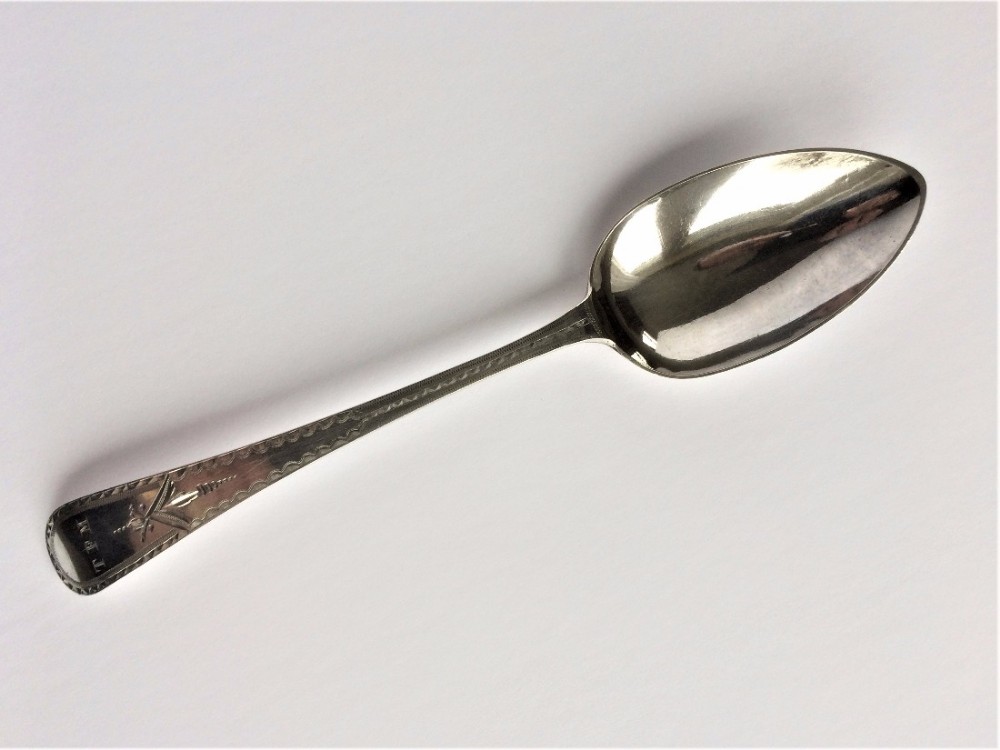 A superb George III bright cut silver serving spoon.