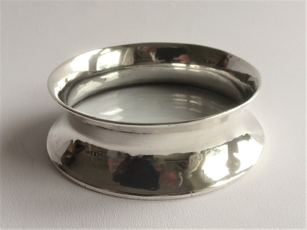 A desirable Edwardian silver wine bottle coaster.