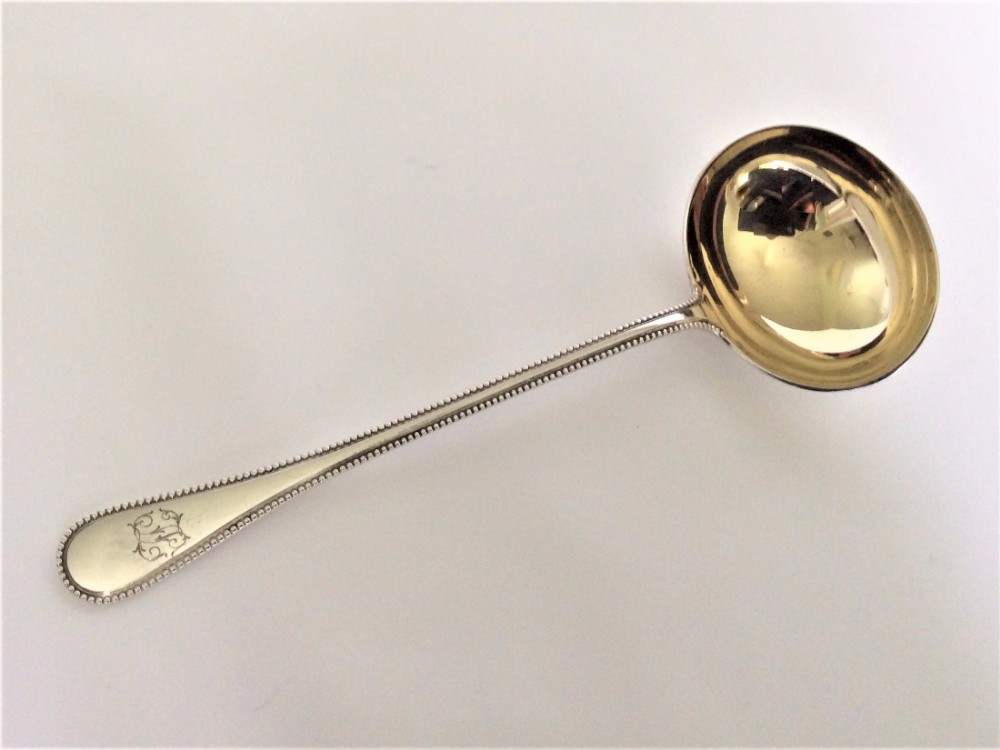 A handsome German silver gilt gravy ladle.