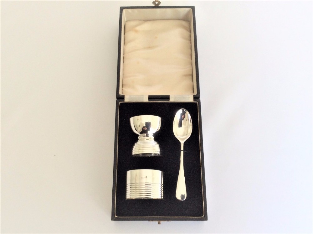 An Art Deco boxed silver egg cup, spoon & napkin ring.