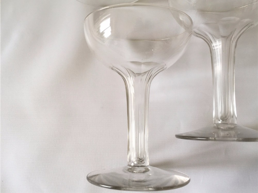 A set of four small hollow stem champagne glasses. View IV